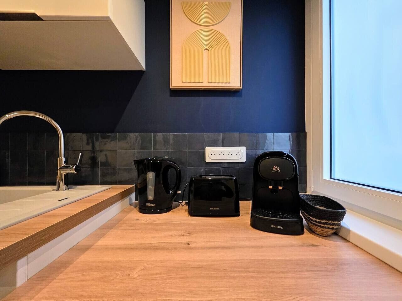 Eine moderne Küche mit Kaffeemaschine, Toaster und Wasserkocher auf der Arbeitsfläche.