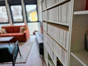 Una biblioteca con scaffali, un divano e un tavolo.