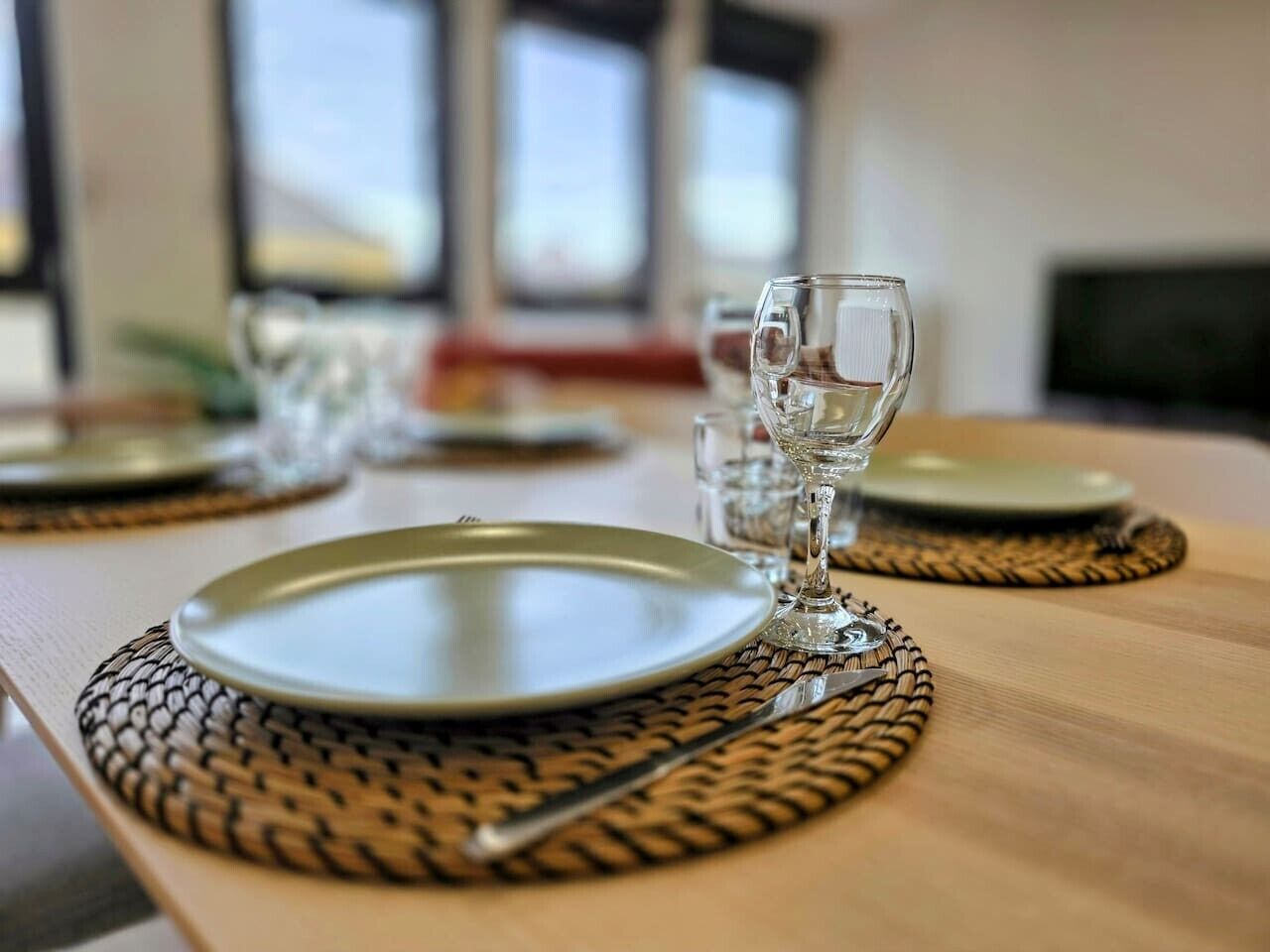 Ein Esstisch mit Tellern, Besteck und einem Glas.