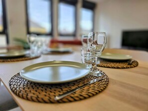 Ein Esstisch mit Tellern, Besteck und einem Glas.