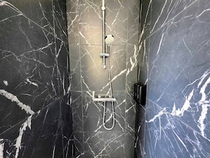 A bathroom with a shower and a handheld showerhead. - Charming 55-square-meter duplex, 15 minutes from Strasbourg (Schiltigheim)