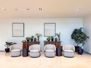 A modern waiting area with four armchairs, two side tables, and two framed artworks on the wall. - Vogue, Acacia Direct Access to Dubai Hills Park (Dubai)