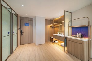 A modern hotel room with a wooden floor, a large mirror, a sink with a countertop, and a door with a sign. - Poltton Century Hotel (Shenzhen International Exhibition Center Buyong Metro Station Branch) (Shenzhen)