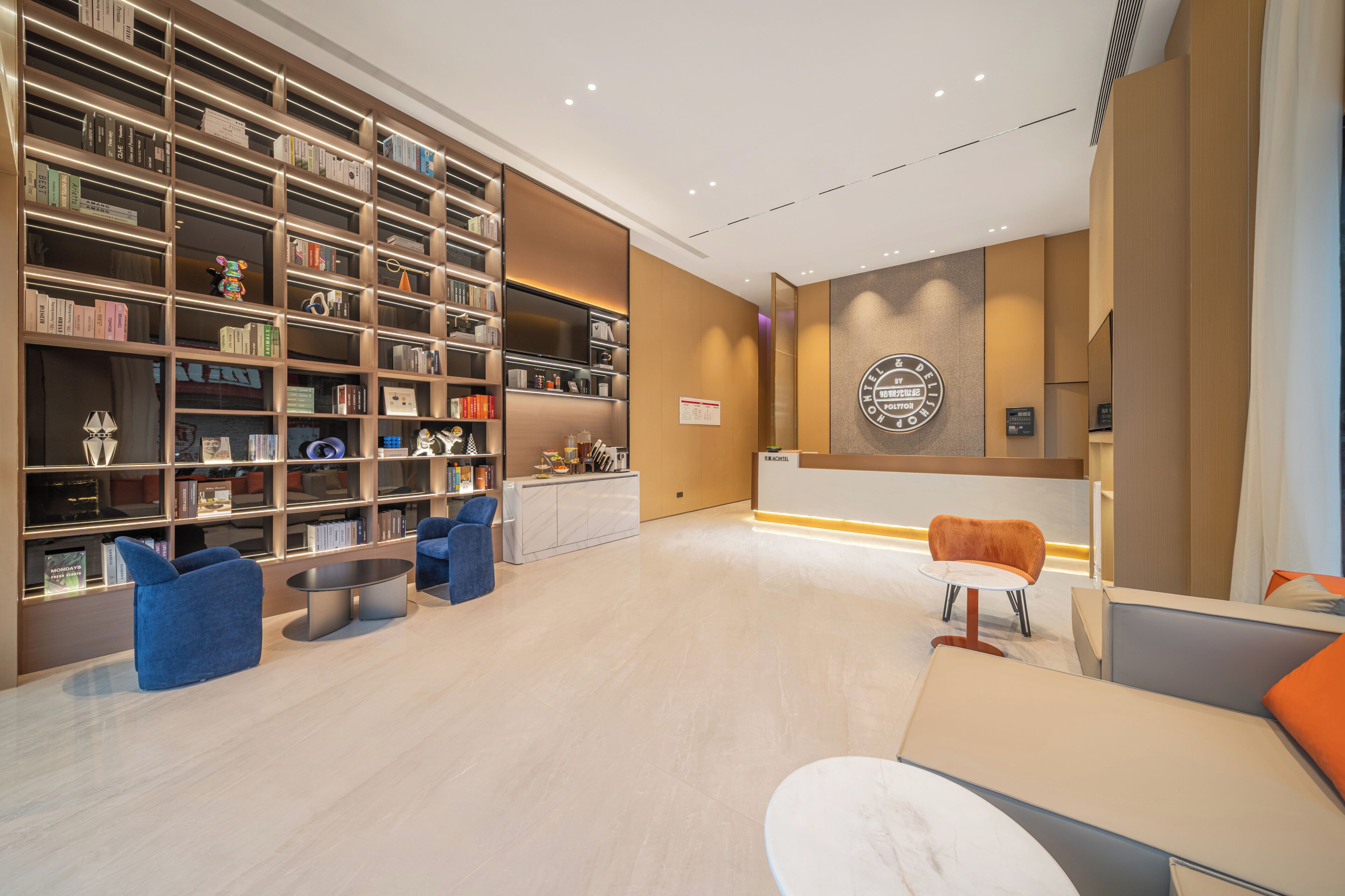 Eine moderne Hotelhalle mit einer großen Bücherwand, Sitzbereichen und einer Rezeption.