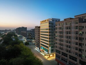 A multi-story hotel with a modern facade, large windows, and a prominent entrance with signage. - Poltton Century Hotel (Shenzhen International Exhibition Center Buyong Metro Station Branch) (Shenzhen)