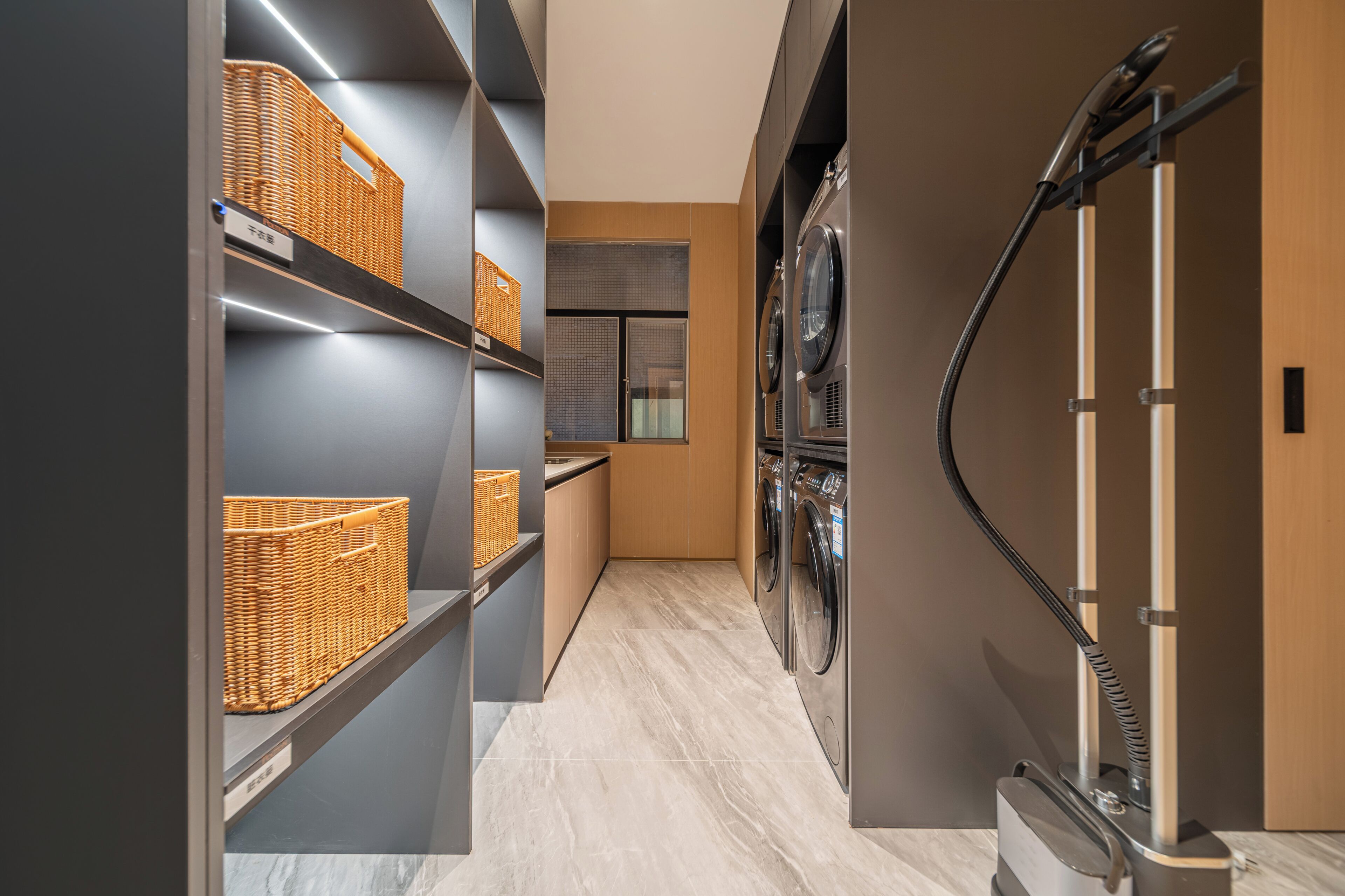 A laundry area with shelves, baskets, and a dryer.