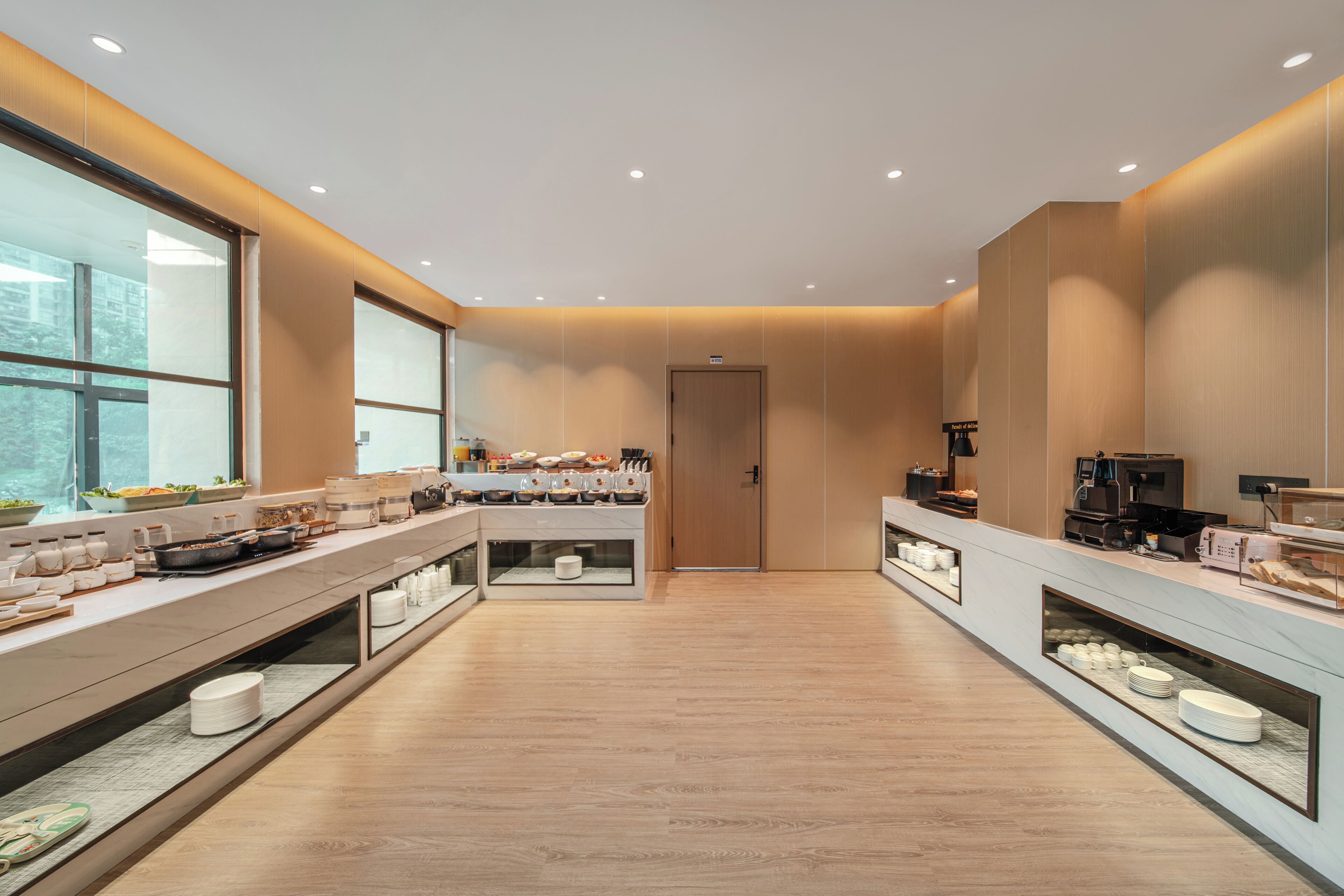 Una cocina moderna con una encimera larga, equipada con diversos electrodomésticos y alimentos.