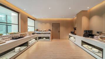 Una cocina moderna con una encimera larga, equipada con diversos electrodomésticos y alimentos.