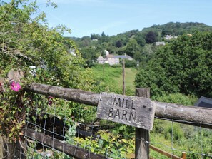 A wooden fence with a sign that reads 'MILL BARN.' - Lustleigh Mill Barn (Newton Abbot)