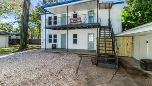 A two-story house with a balcony, a front porch, and a garage. - Comfortable 3BR Home Near Downtown (Lafayette)