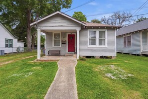 A single-story house with a front porch, a red door, and a small front yard. - Spacious 2BR Perfect for Work Crews or Families (Lafayette)