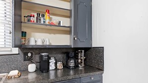 A kitchen with a coffee maker, a kettle, and a cabinet with various spices. - Private Bedroom in 4BR Home (Lafayette)