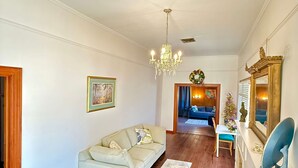 Ein Wohnzimmer mit Sofa, einer Deckenleuchte, einem Kamin und einem Essbereich.