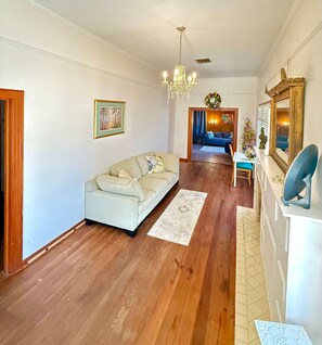 Ein Wohnzimmer mit Sofa, einer Deckenleuchte, einem Kamin und einem Essbereich.