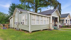 Einbungalow mit Veranda, überdachter Hauseingangsbereich und einer kleinen angebauten Garage.