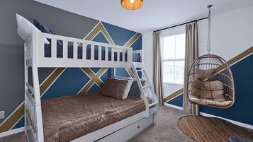 A bunk bed with a patterned bedspread, a hanging chair, and a geometric wall design.