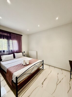 A modern bedroom with a bed, a radiator, and a chair. - Moonlit Olives - Corfu Luxurious Stylish Escape (Corfu)