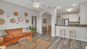 A modern living room with a sofa, coffee table, and decorative wall art. - Upstay Large Family Condo w Pool Sauna (Winter Garden)