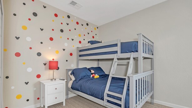 A bunk bed with a nightstand and a lamp, a polka dot wall, and a carpeted floor. - Upstay Large Family Condo w Pool Sauna (Winter Garden)