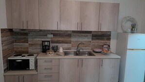 Una cocina con armarios de madera, estufa, fregadero y refrigerador.