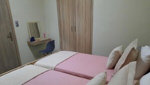 A bedroom with two beds, a desk, a chair, and a wardrobe. - Apartment 'Chrissi Princess 1' with Private Garden, Wi-Fi and Air Conditioning (Skala Sotiros)