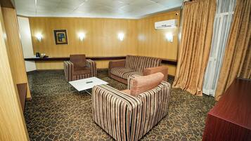 Una habitación de hotel con sofá, sillón y una mesita.