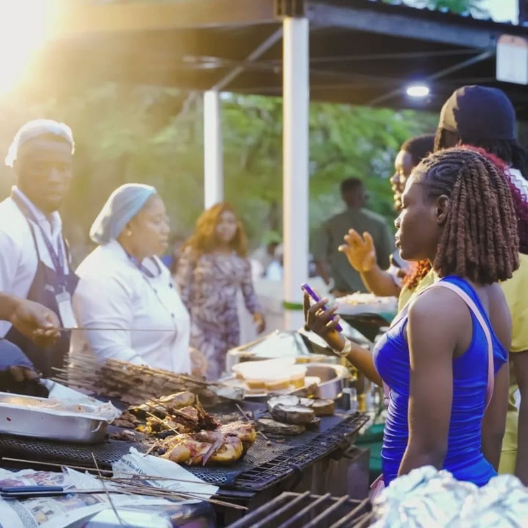 Un grupo de personas reunidas alrededor de una parrilla al aire libre.