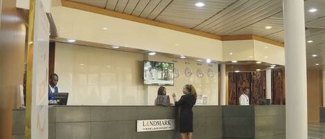A reception desk at a hotel with a sign indicating it's the Landmark Nike Lake Resort.