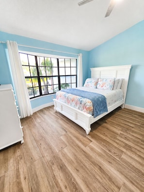 A bedroom with a bed, a window, and a ceiling fan. - Casa Azul - 4Br/2Ba Pool & Spa Home, Sleeps 10 (Port St. Lucie)
