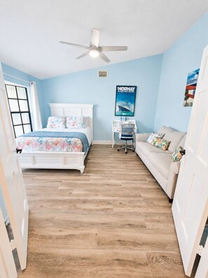 A bedroom with a bed, a nightstand, a chair, and a poster on the wall. - Casa Azul - 4Br/2Ba Pool & Spa Home, Sleeps 10 (Port St. Lucie)