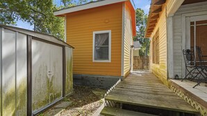 A small, single-story building with a wooden deck leading to a covered patio area. - Cozy 1BR Near Downtown Lafayette (Lafayette)