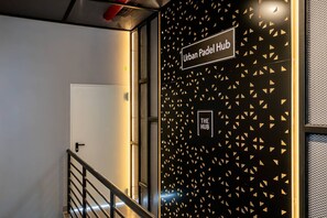 A stairway leading to an area labeled 'Urban Padel Hub' with a patterned wall and a door. - w Scenic 1BR w Balcony View in San Francisco (Panama City)