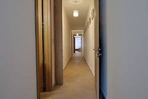 A hallway with wooden doors, a light fixture, and framed pictures on the wall. - Sunny 3BR Qala home w/Pool & Balcony, WIFI in Gozo (Qala)