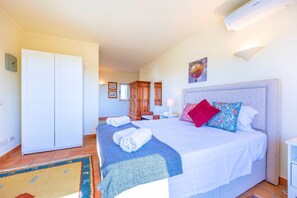 A hotel room with a bed, a wardrobe, a desk, and a chair. - Casa Serrao | Carvoeiro | Private Pool & Sea Glimpses | Walk to Dining & Beaches (Carvoeiro)