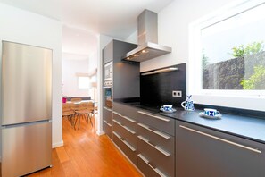 A modern kitchen with stainless steel appliances, a black countertop, and a window with a view of greenery. - Villa Maravento | Playa Blanca | Heated Pool | Family Luxury Retreat (Playa Blanca)
