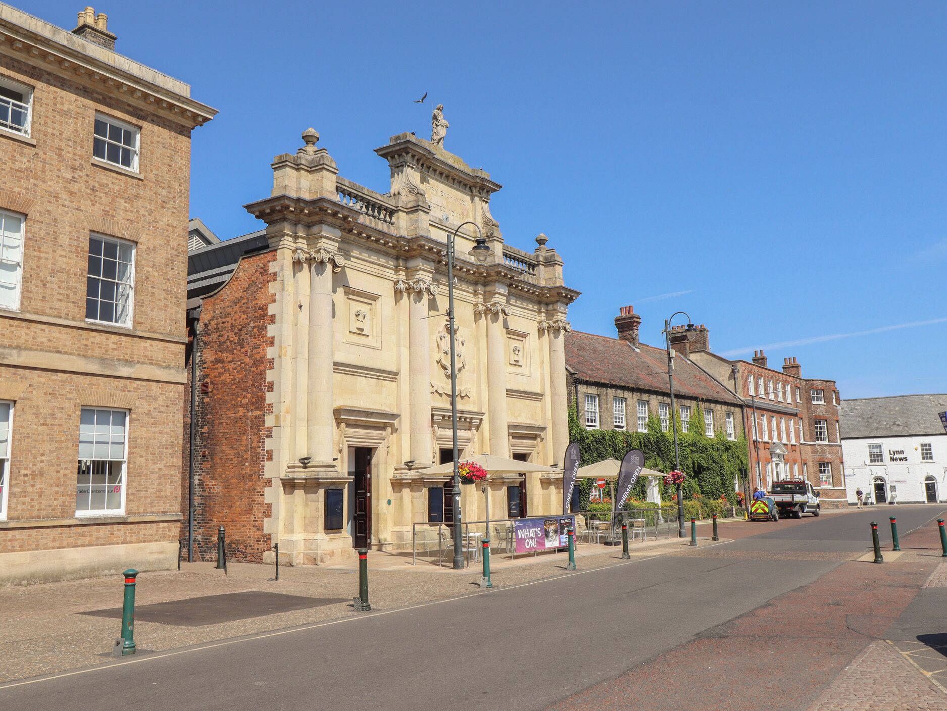 A historic building with classical architecture, a street in front, and a cinema sign.
