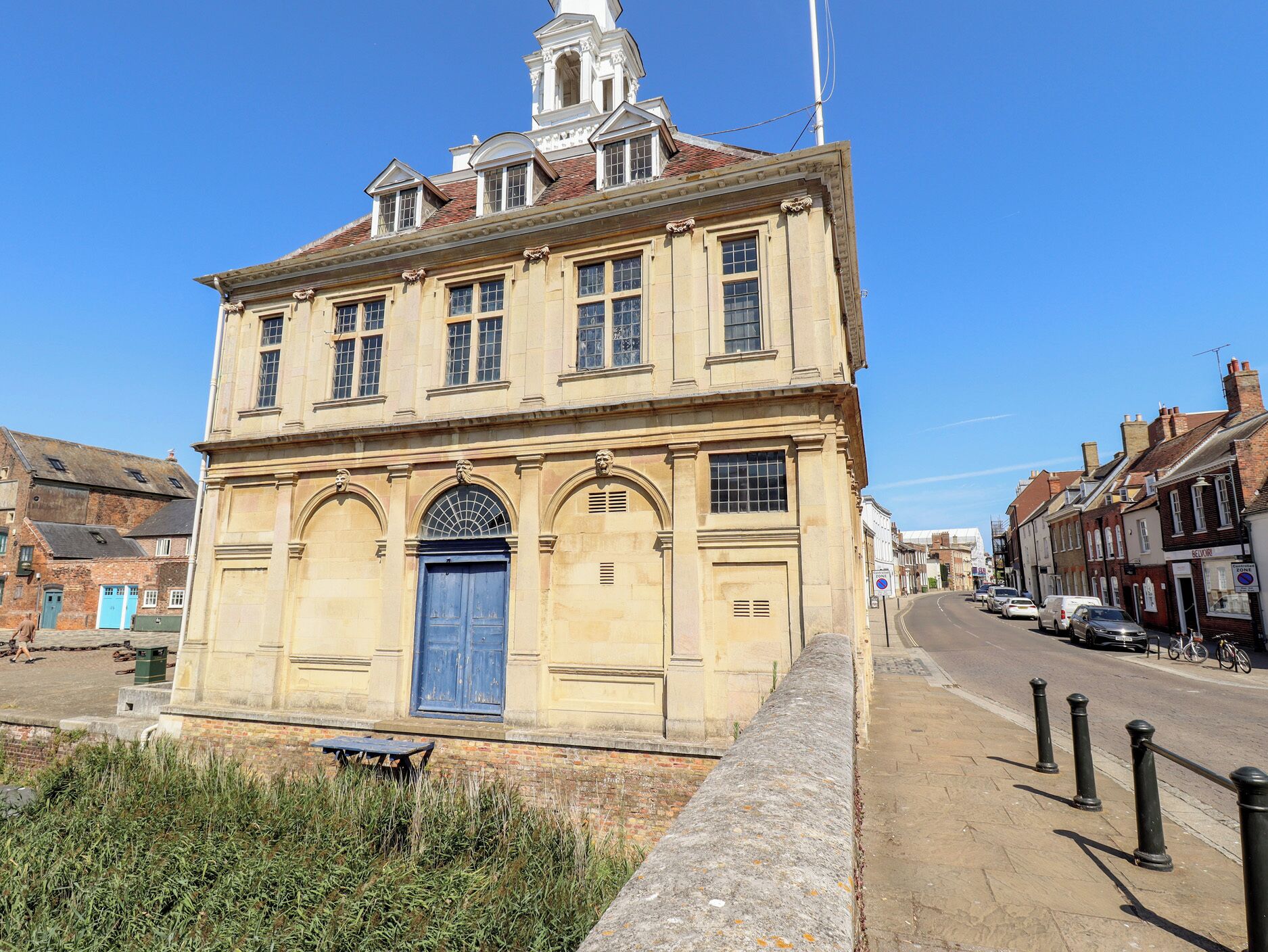 A historic building with a prominent central entrance, a clock tower, and a traditional facade.