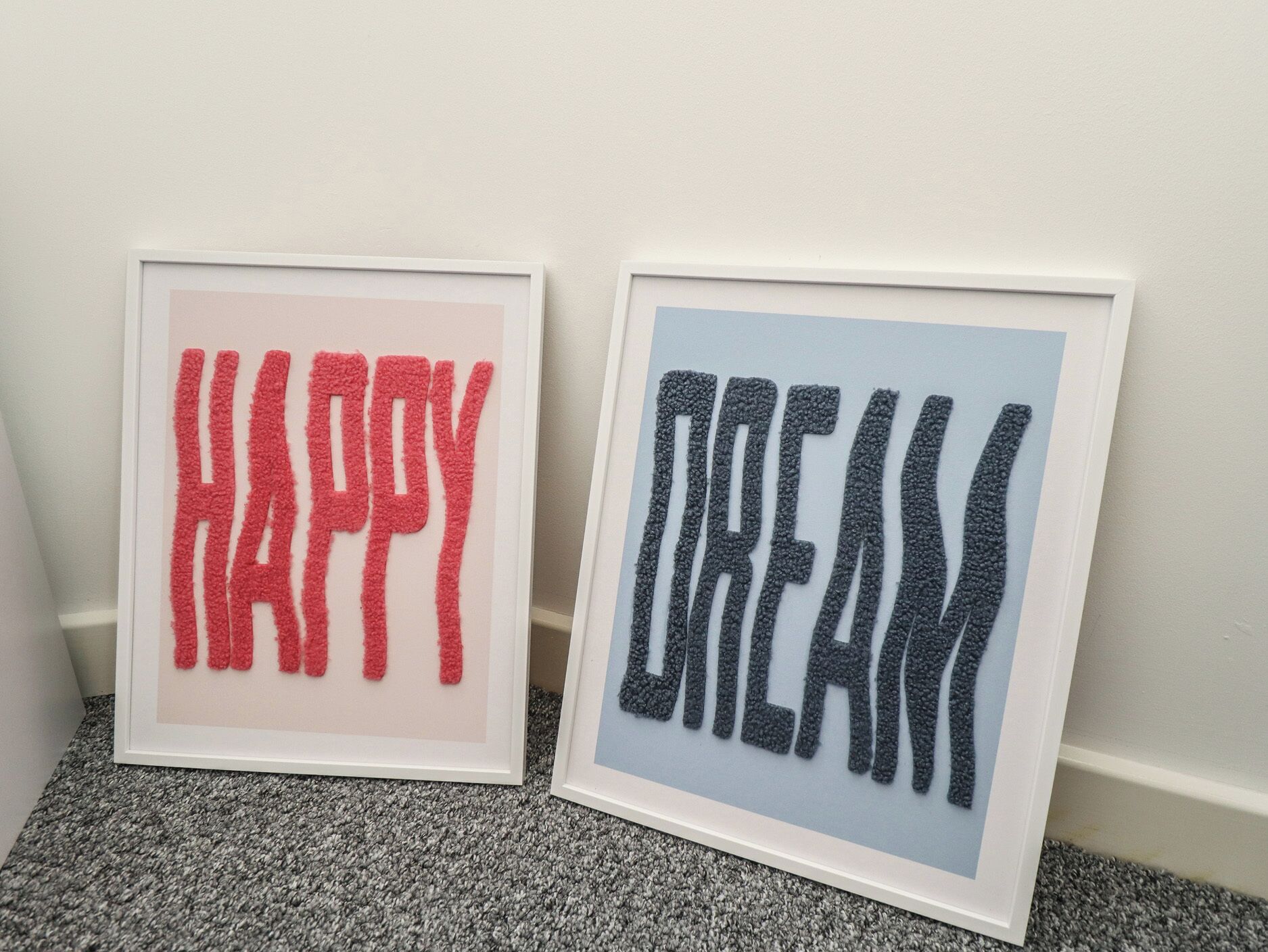 Deux panneaux encadrés, ornés des mots « HAPPY » et « DREAM » dans un style texturé.