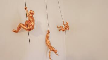 Three golden sculptures suspended from the ceiling.