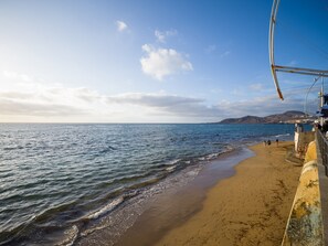 A beach with a clear sky, calm sea, and a sandy shore. - Studio in Las Palmas Near Playa de Las Canteras (Las Palmas de Gran Canaria)