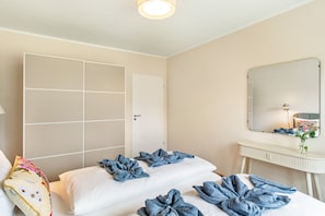 Ein Hotelzimmer mit Bett, Nachttisch, Spiegel und Kleiderschrank.