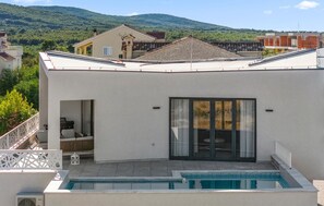 A modern building with a swimming pool, large windows, and a view of a mountainous landscape. - Pet friendly home in Vodice (Vodice)