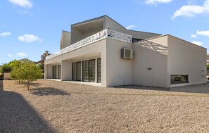A modern two-story building with a flat roof, large windows, and a balcony with a lattice design. - Pet friendly home in Vodice (Vodice)