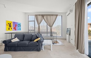 A modern living room with a grey sofa, a white coffee table, and a large window with curtains. - Pet friendly home in Vodice (Vodice)