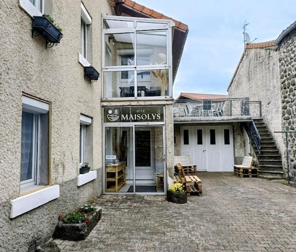 Un edificio con un letrero que dice 'MAISOLYS' y una entrada visible.