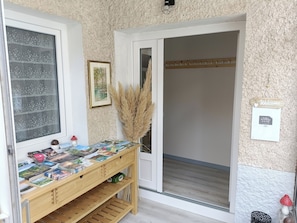 Una habitación con un escritorio de madera que muestra folletos de viaje, un cuadro en la pared y un cartel que dice 'Bienvenido'.