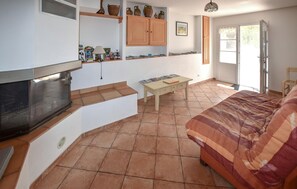 Un espace de vie compact comprenant un coin cuisine, une table à manger, un canapé et une cheminée.