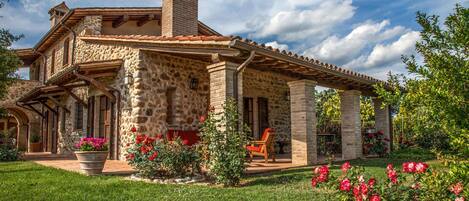 A stone house with a patio and garden.