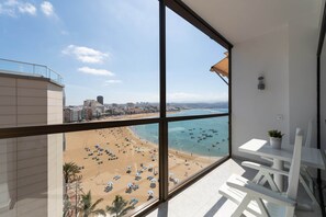 Ein Balkon mit freiem Blick auf Strand und Stadtlandschaft.