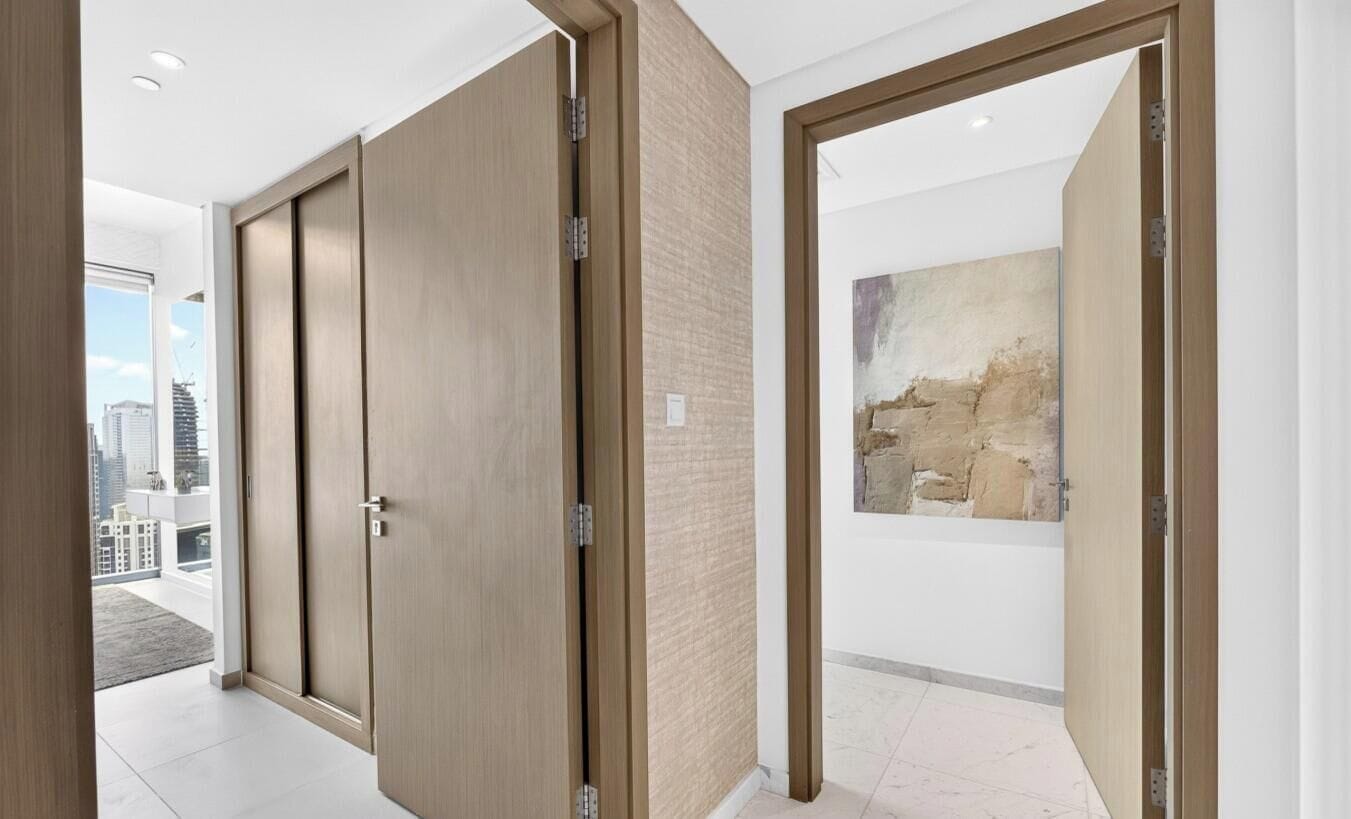 Ein modernes Interieur mit Schiebetüren, einer strukturierten Wand und einem großen abstrakten Gemälde.